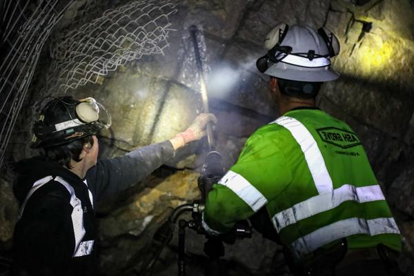Two students drilling in an underground mine